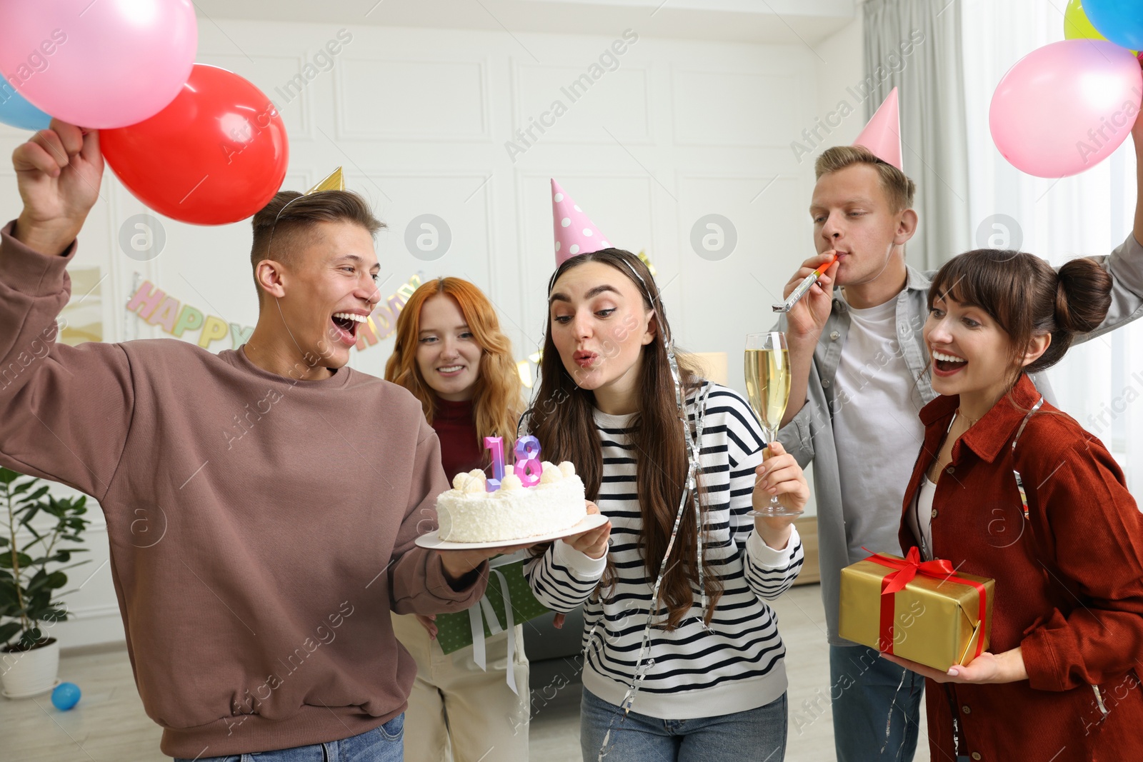 Photo of 18th birthday. Group of friends with tasty cake having coming of age party at home