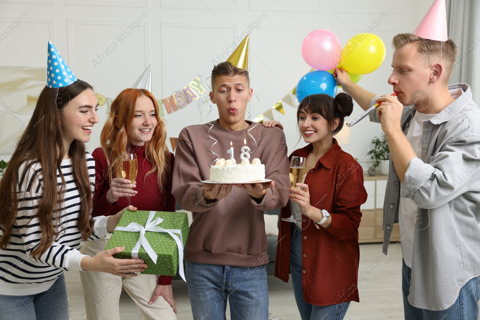 Photo of 18th birthday. Group of friends with tasty cake having coming of age party at home