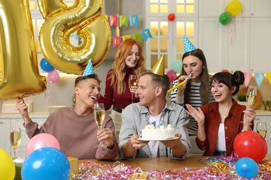 Photo of 18th birthday. Group of friends with tasty cake having coming of age party at home