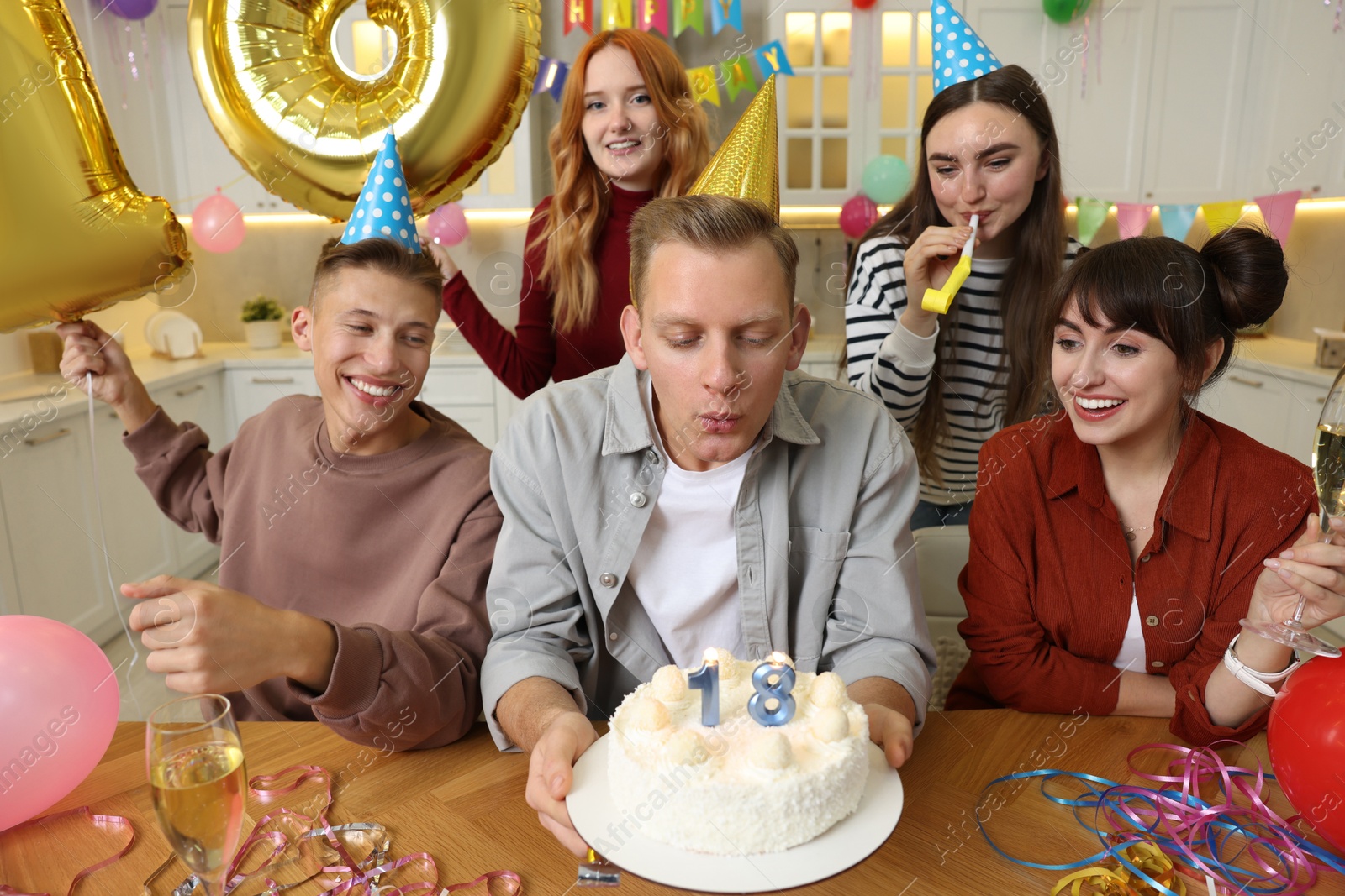 Photo of 18th birthday. Group of friends with tasty cake having coming of age party at home