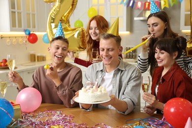 21st birthday. Group of happy friends with tasty cake having coming of age party at home