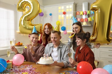 Photo of 21st birthday. Group of happy friends with tasty cake having coming of age party at home