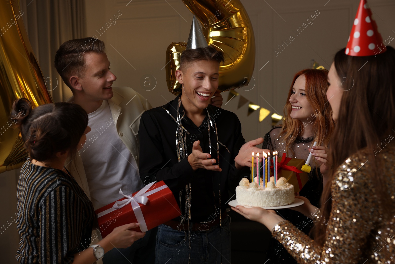 Photo of 21st birthday. Group of happy friends with tasty cake having coming of age party at home