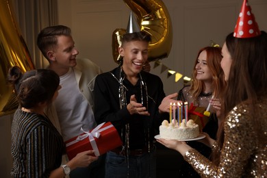 Photo of 21st birthday. Group of happy friends with tasty cake having coming of age party at home