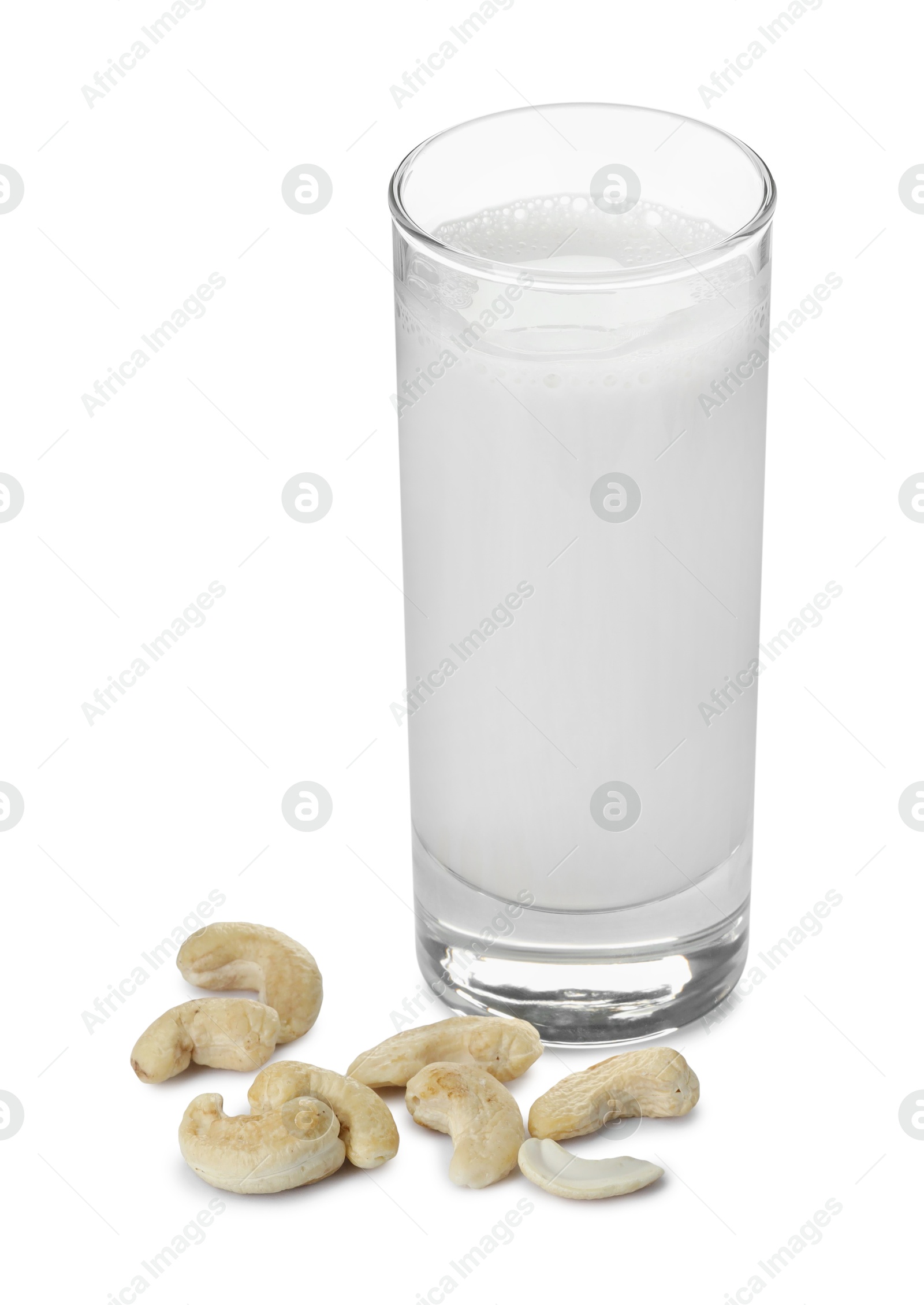 Photo of Fresh cashew milk in glass and nuts isolated on white