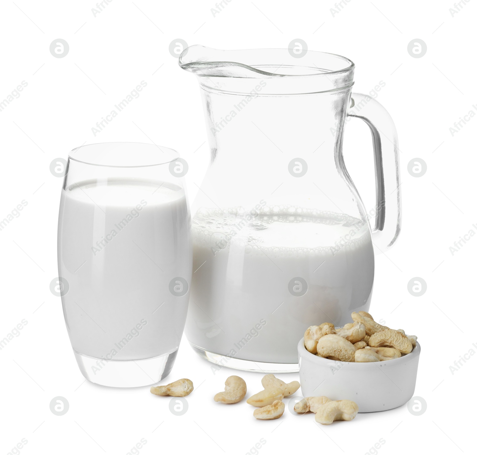 Photo of Fresh cashew milk in glass, jug and nuts isolated on white