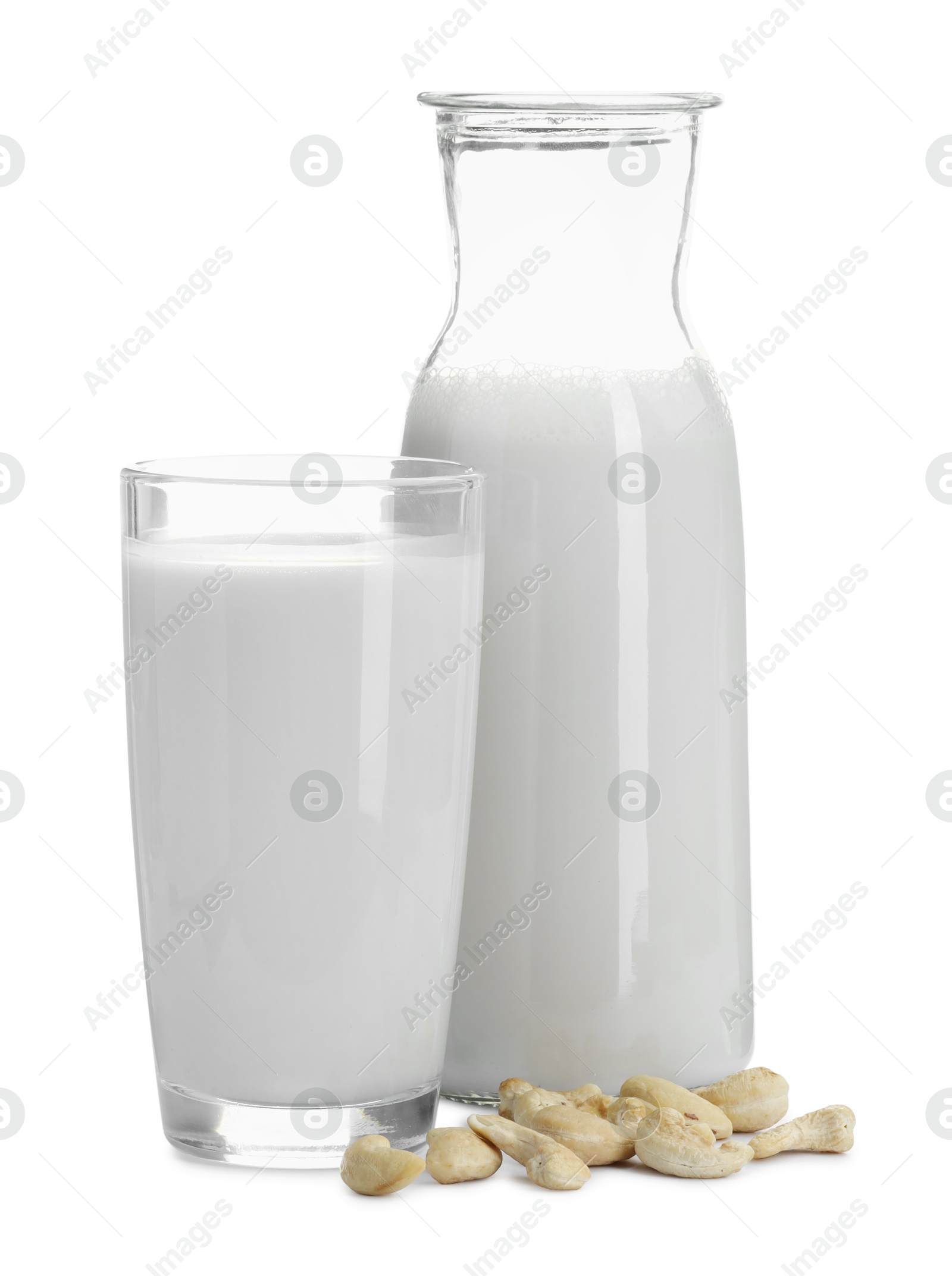 Photo of Fresh cashew milk in glass, carafe and nuts isolated on white