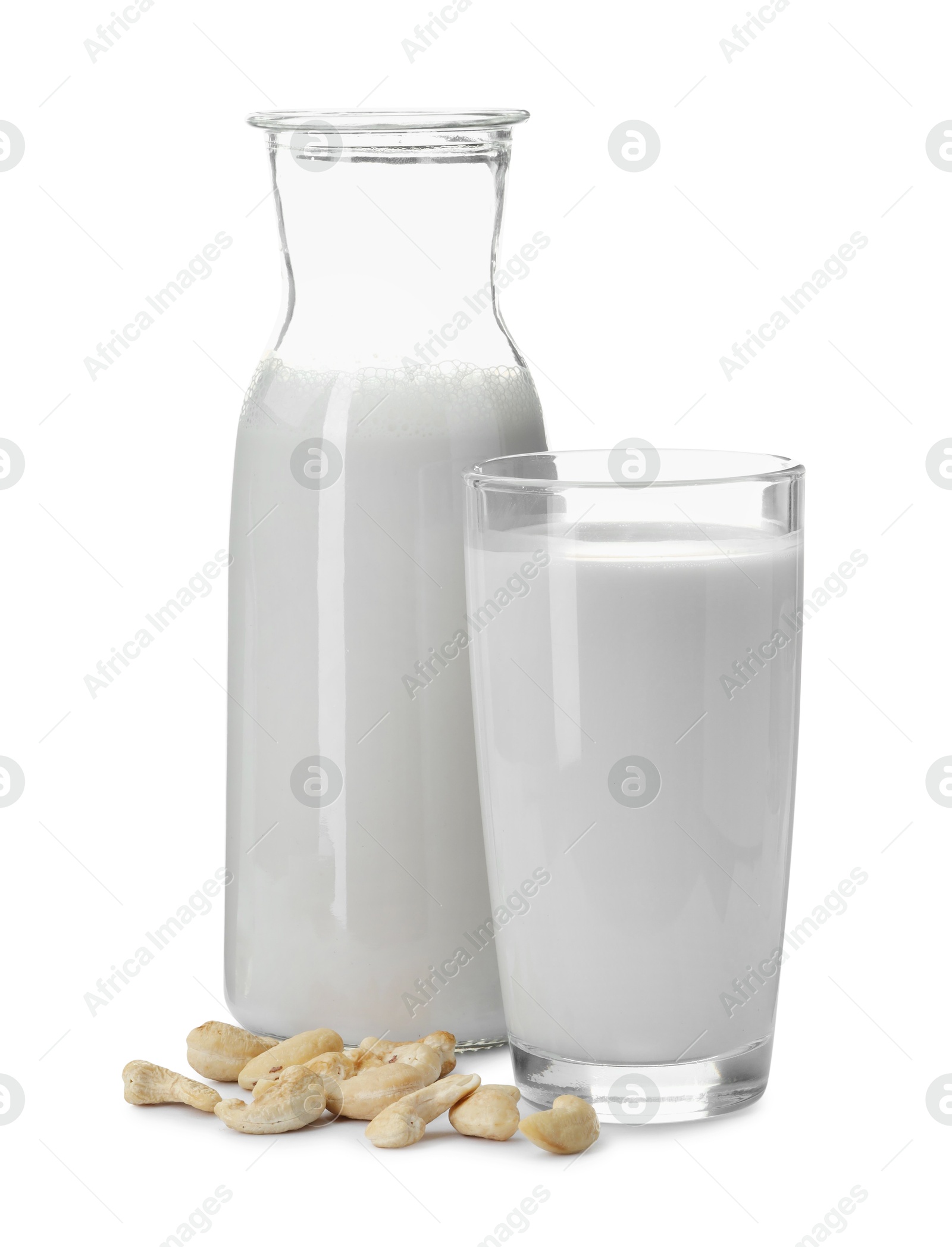 Photo of Fresh cashew milk in glass, carafe and nuts isolated on white