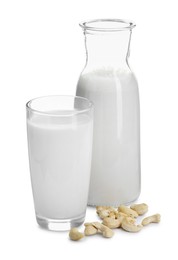 Photo of Fresh cashew milk in glass, carafe and nuts isolated on white