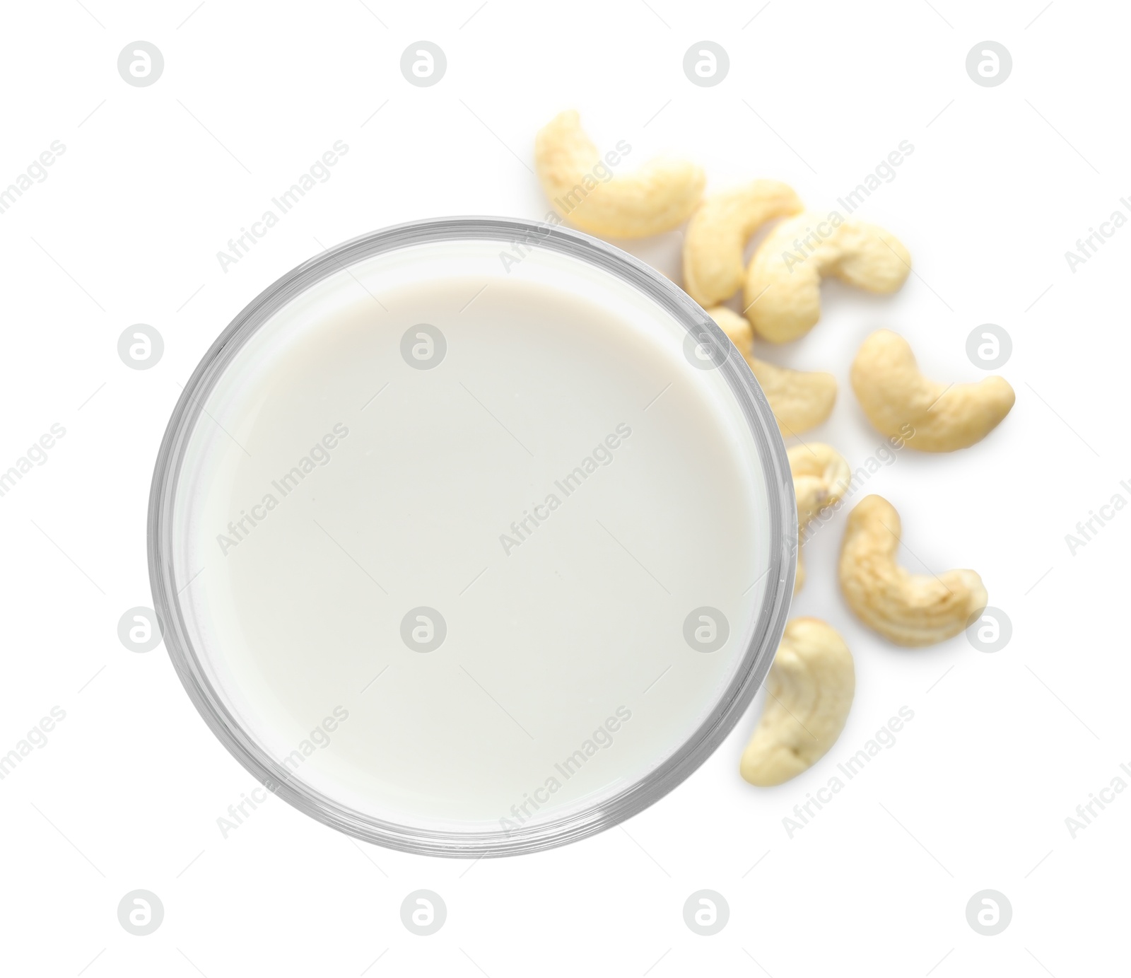 Photo of Fresh cashew milk in glass and nuts isolated on white, top view