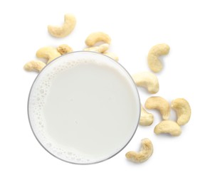 Fresh cashew milk in glass and nuts isolated on white, top view