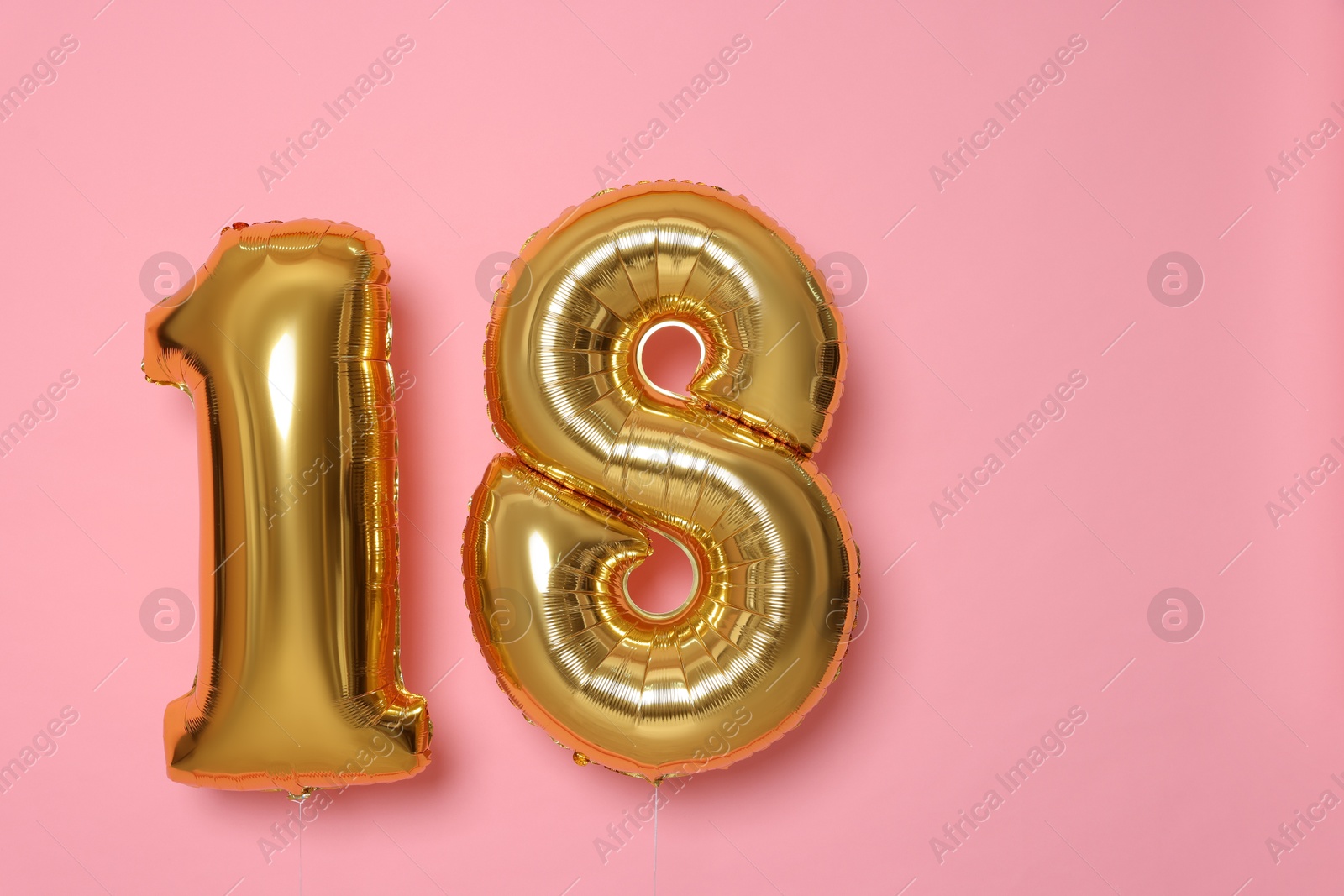 Photo of 18th birthday, coming of age party. Number shaped balloons on pink background, space for text