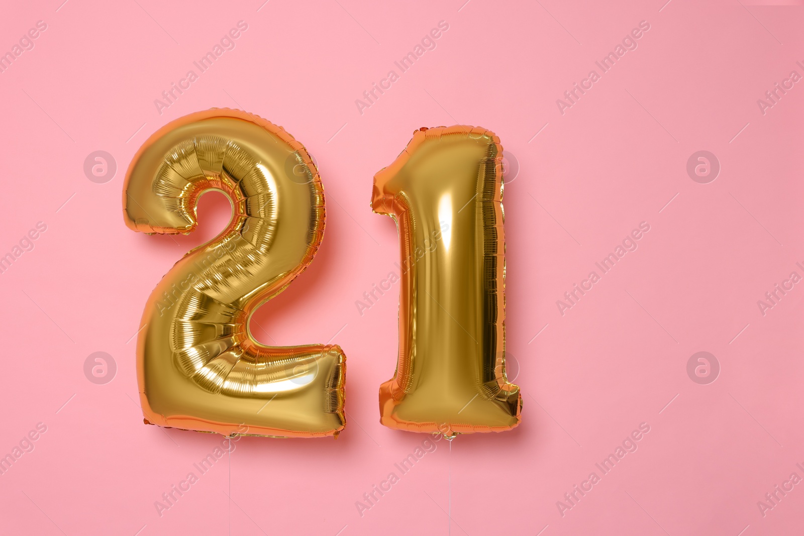 Photo of Coming of age party - 21st birthday. Number shaped balloons on pink background, space for text