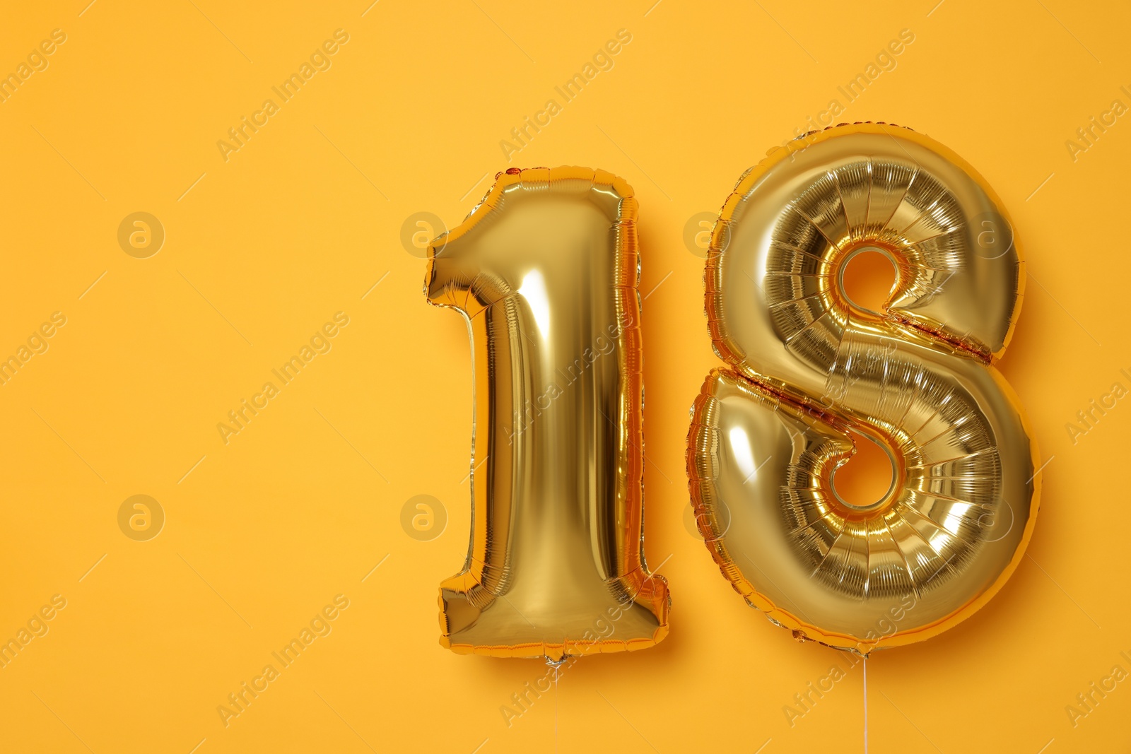 Photo of 18th birthday, coming of age party. Number shaped balloons on orange background, space for text