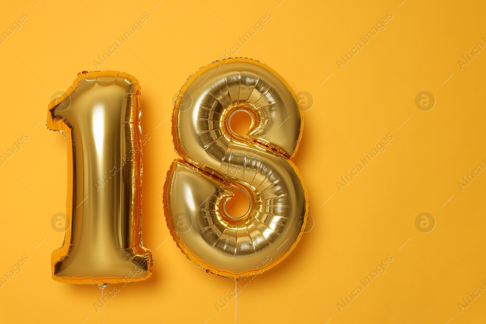 Photo of 18th birthday, coming of age party. Number shaped balloons on orange background, space for text