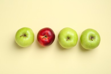 Green apples and red one on beige background, flat lay