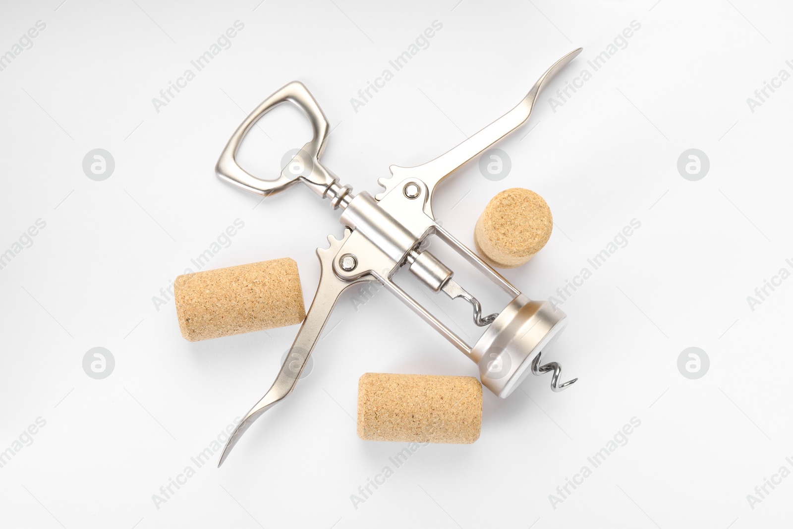 Photo of Wing corkscrew and corks on white background, top view