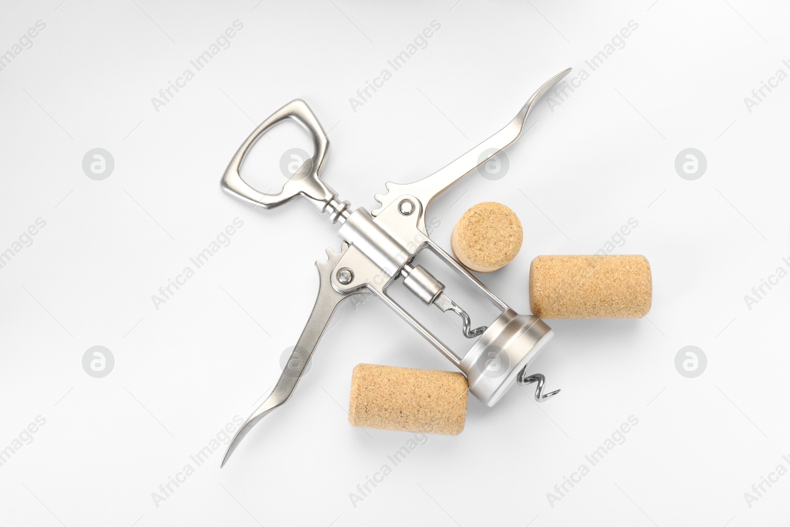 Photo of Wing corkscrew and corks on white background, top view