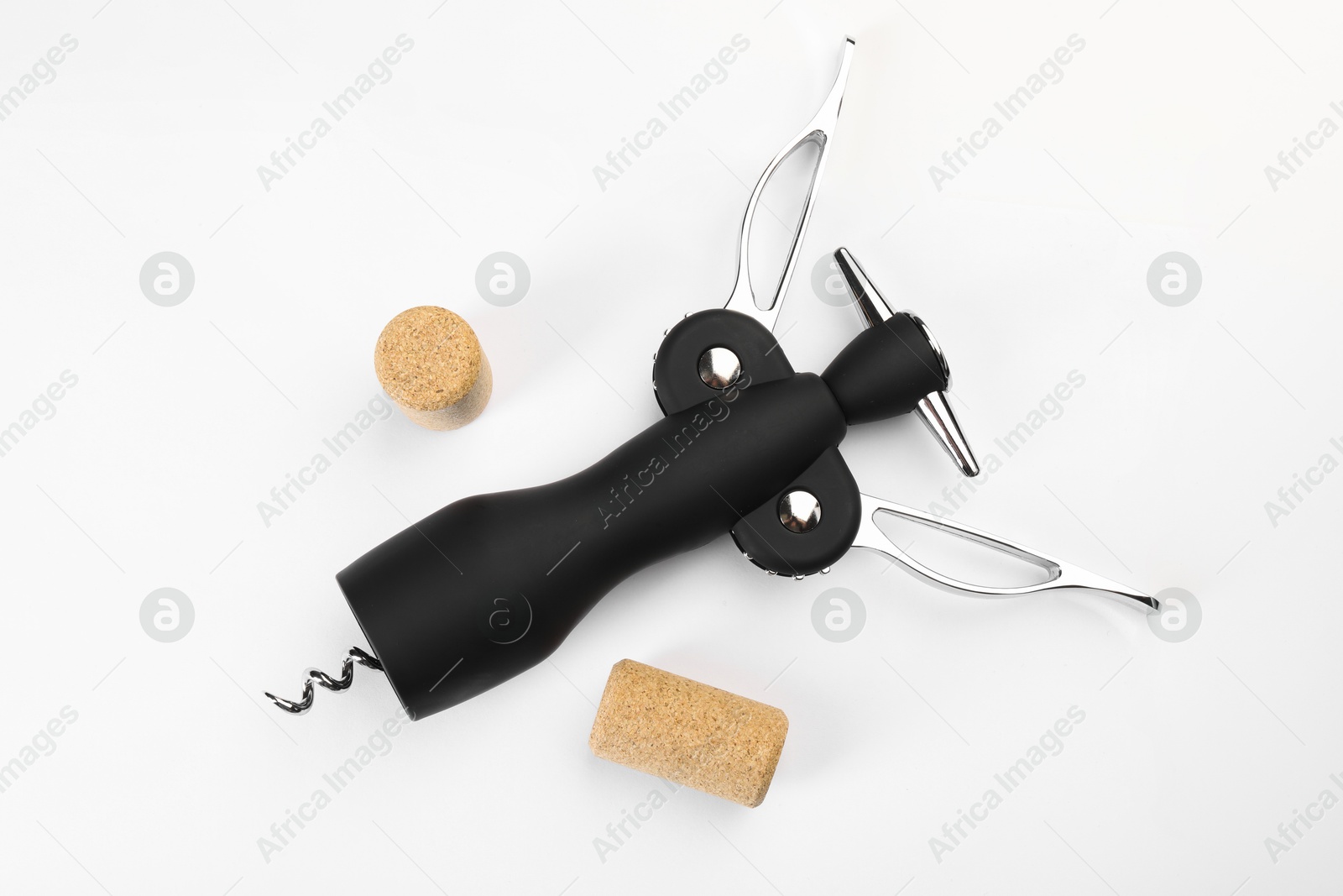 Photo of Wing corkscrew and corks on white background, top view