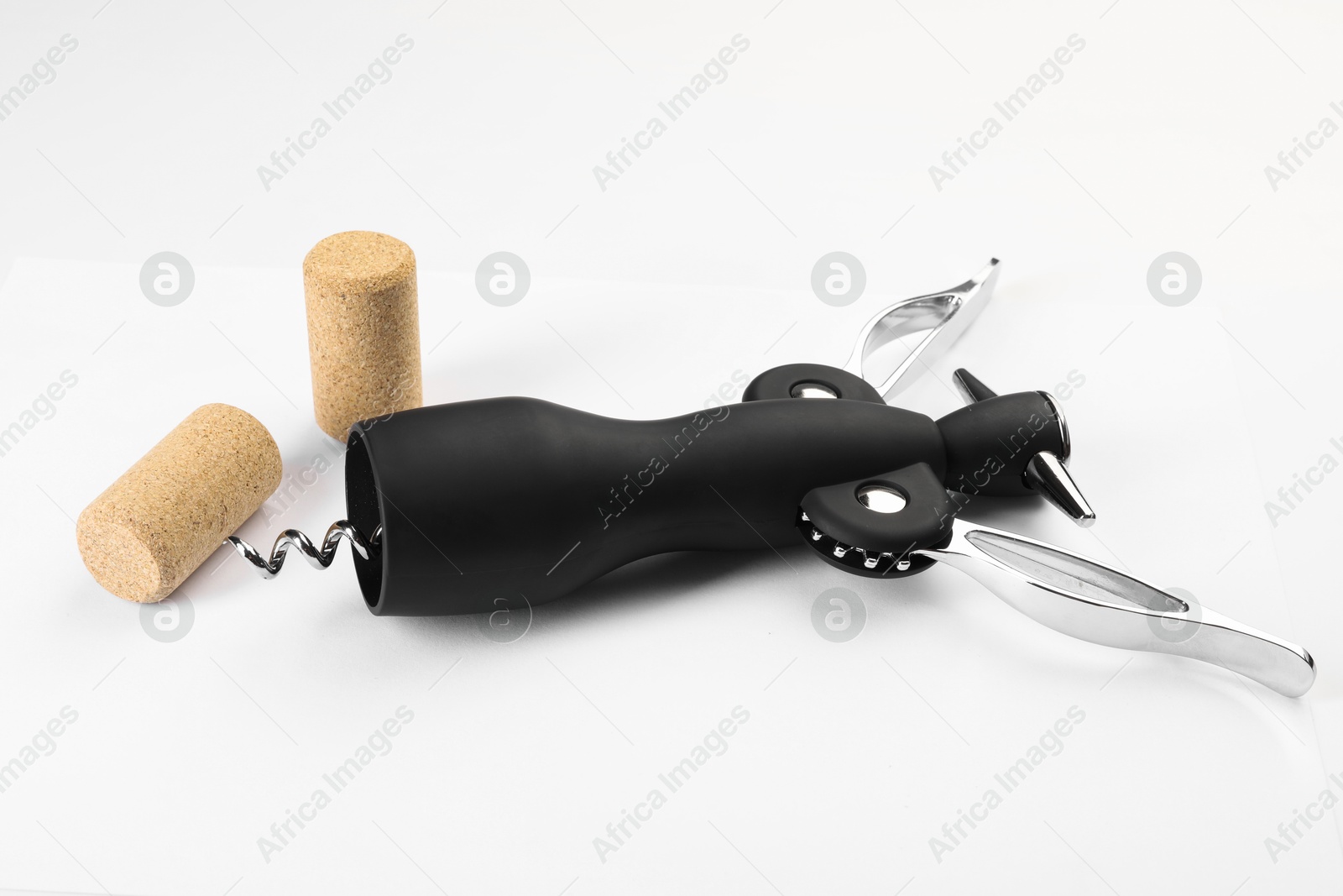 Photo of Wing corkscrew and corks on white background