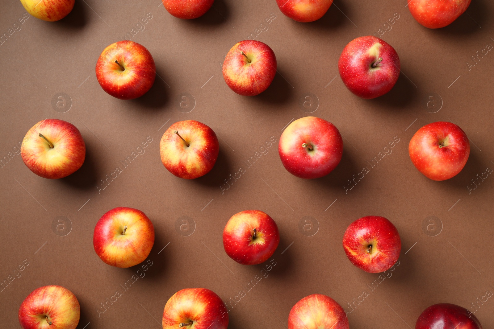 Photo of Ripe red apples on brown background, flat lay