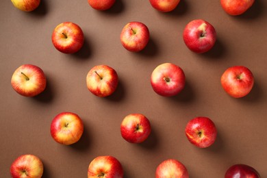 Ripe red apples on brown background, flat lay