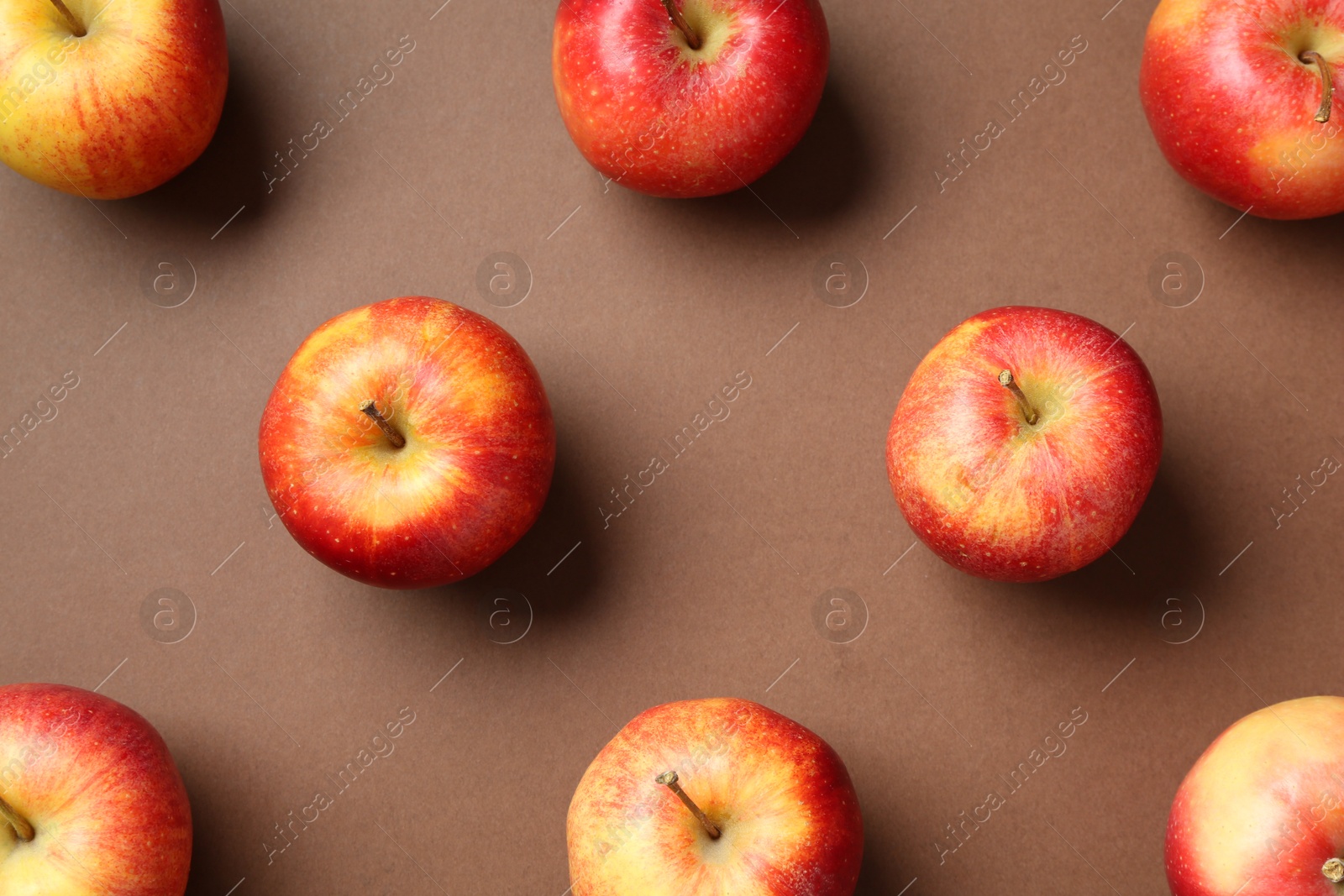 Photo of Ripe red apples on brown background, flat lay