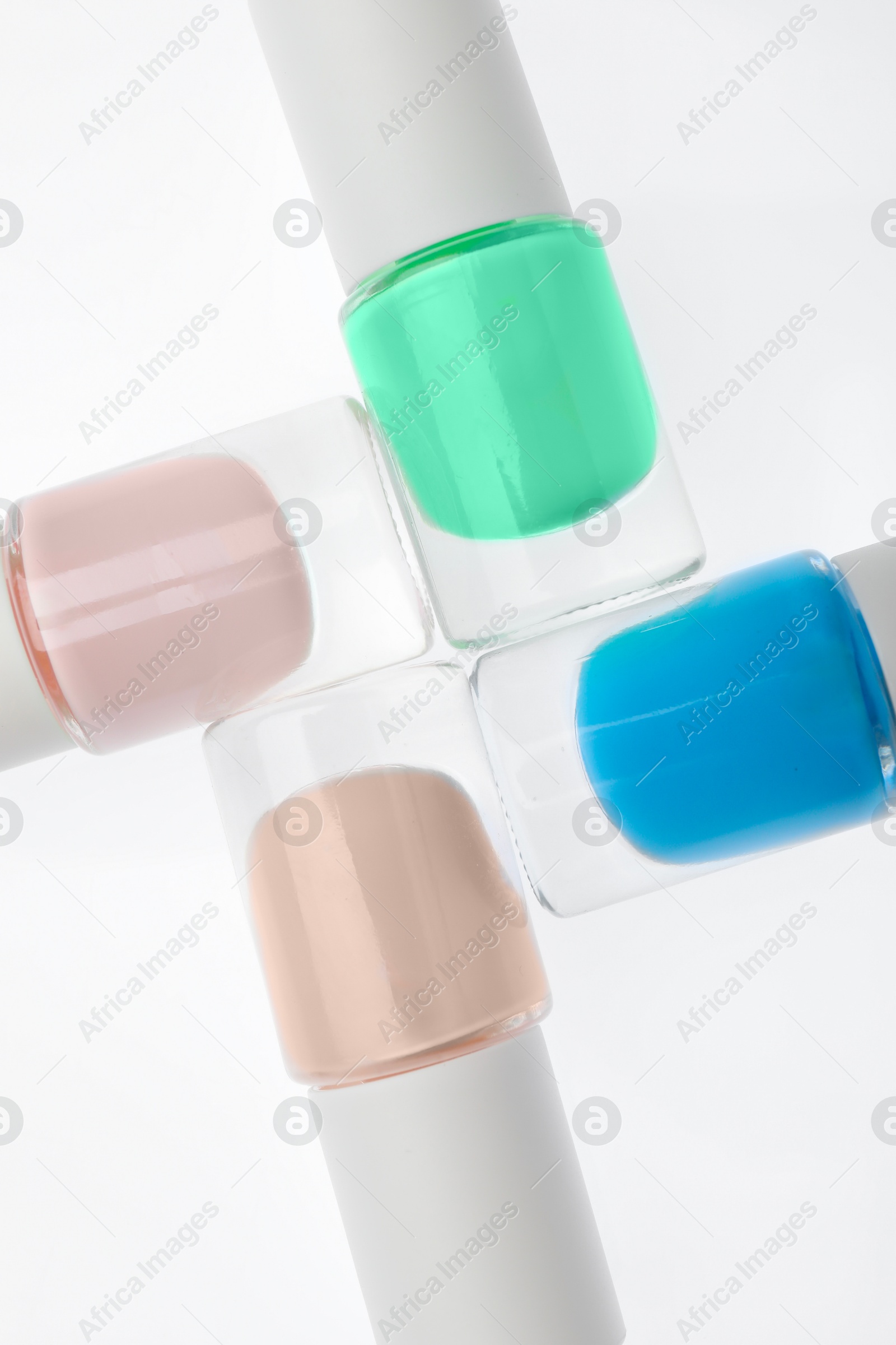 Photo of Nail polishes in bottles on white background, top view