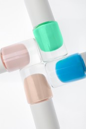 Photo of Nail polishes in bottles on white background, top view