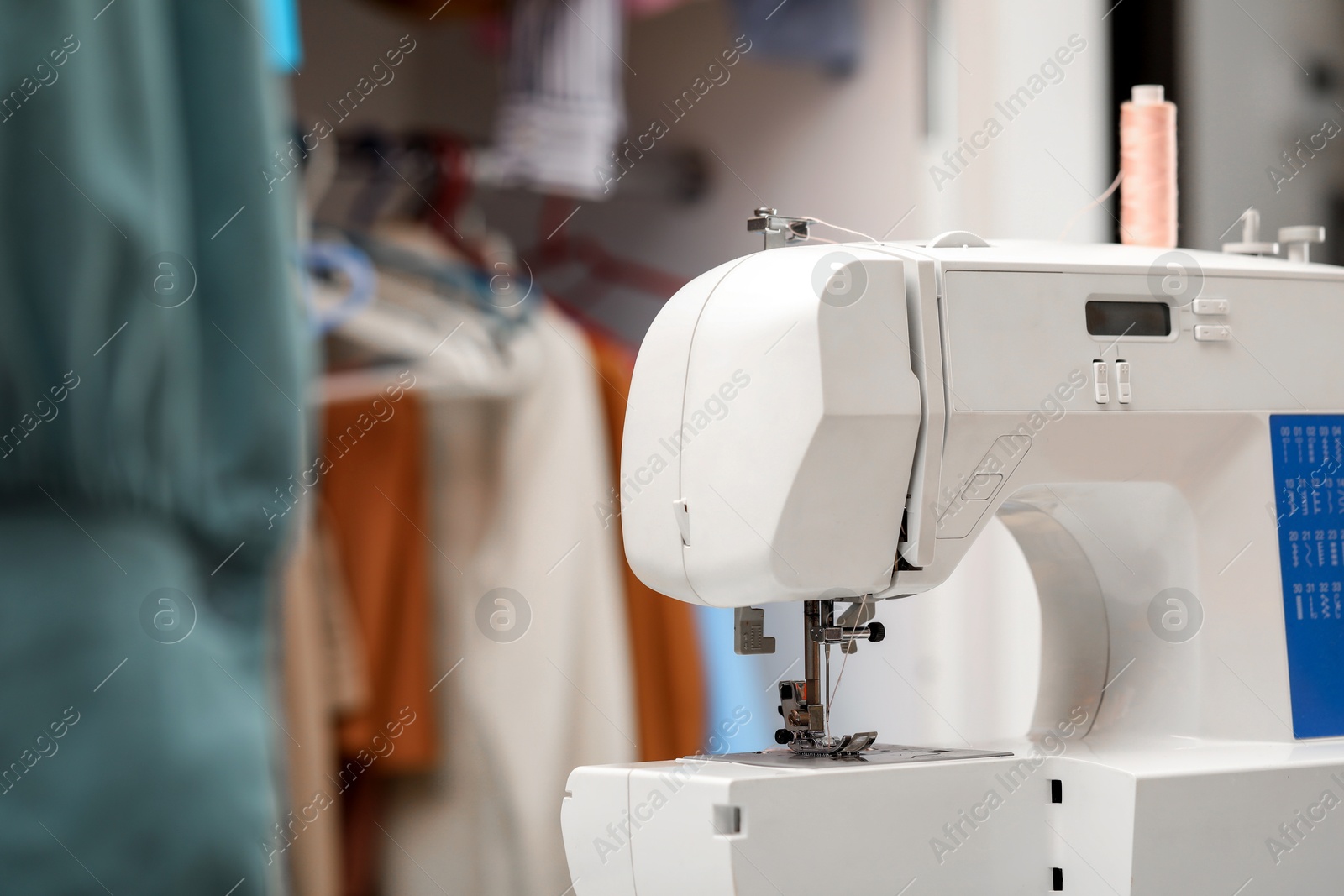 Photo of Sewing machine with thread in workshop, space for text