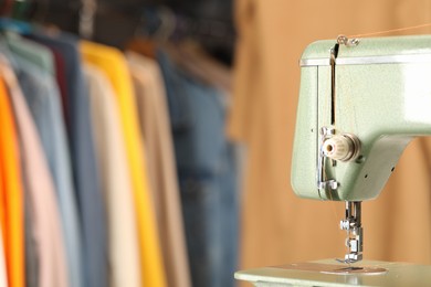 Photo of Vintage sewing machine with thread in workshop, closeup. Space for text