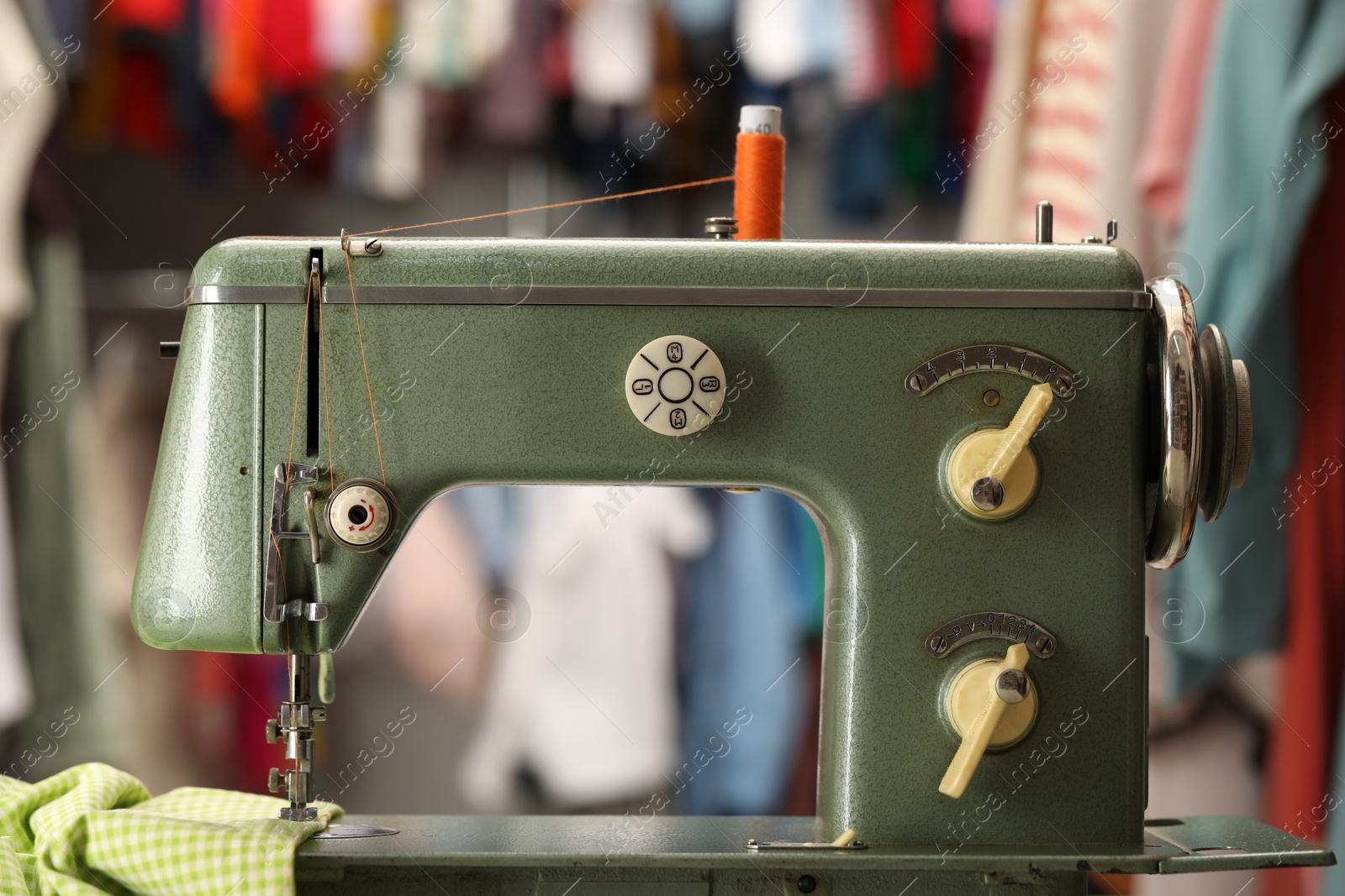 Photo of Vintage sewing machine with thread and fabric in workshop