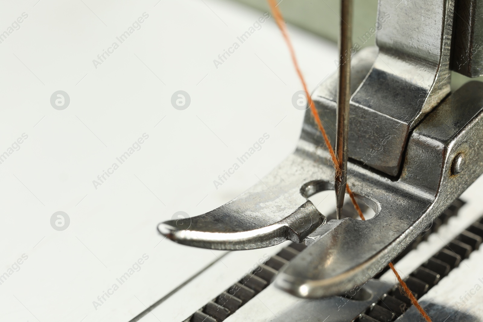 Photo of Sewing machine with thread on white background, macro view. Space for text