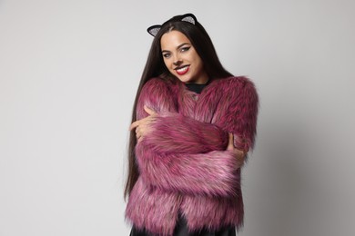 Photo of Smiling woman with cat makeup and ears on white background