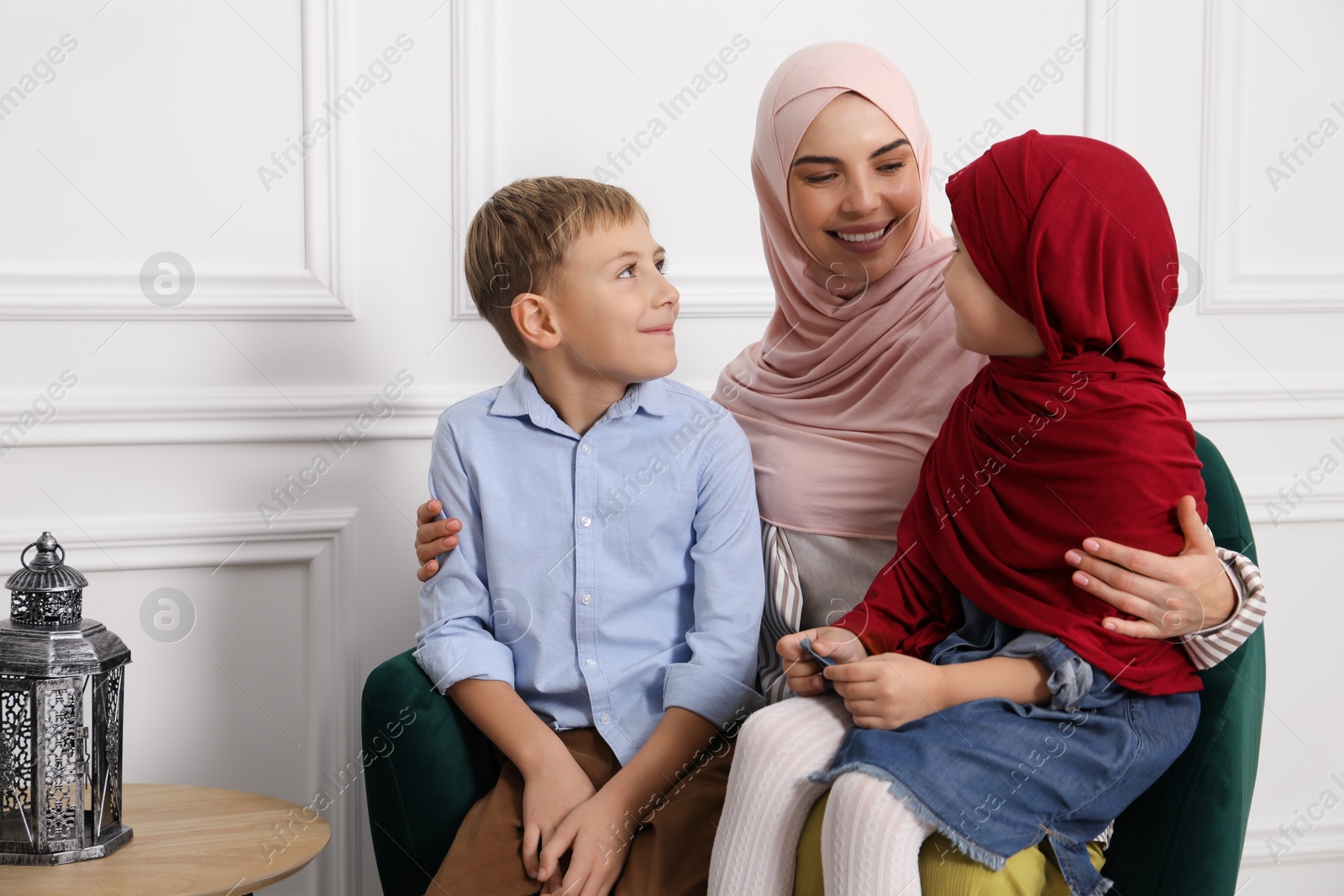 Photo of Muslim woman and her children spending time together at home