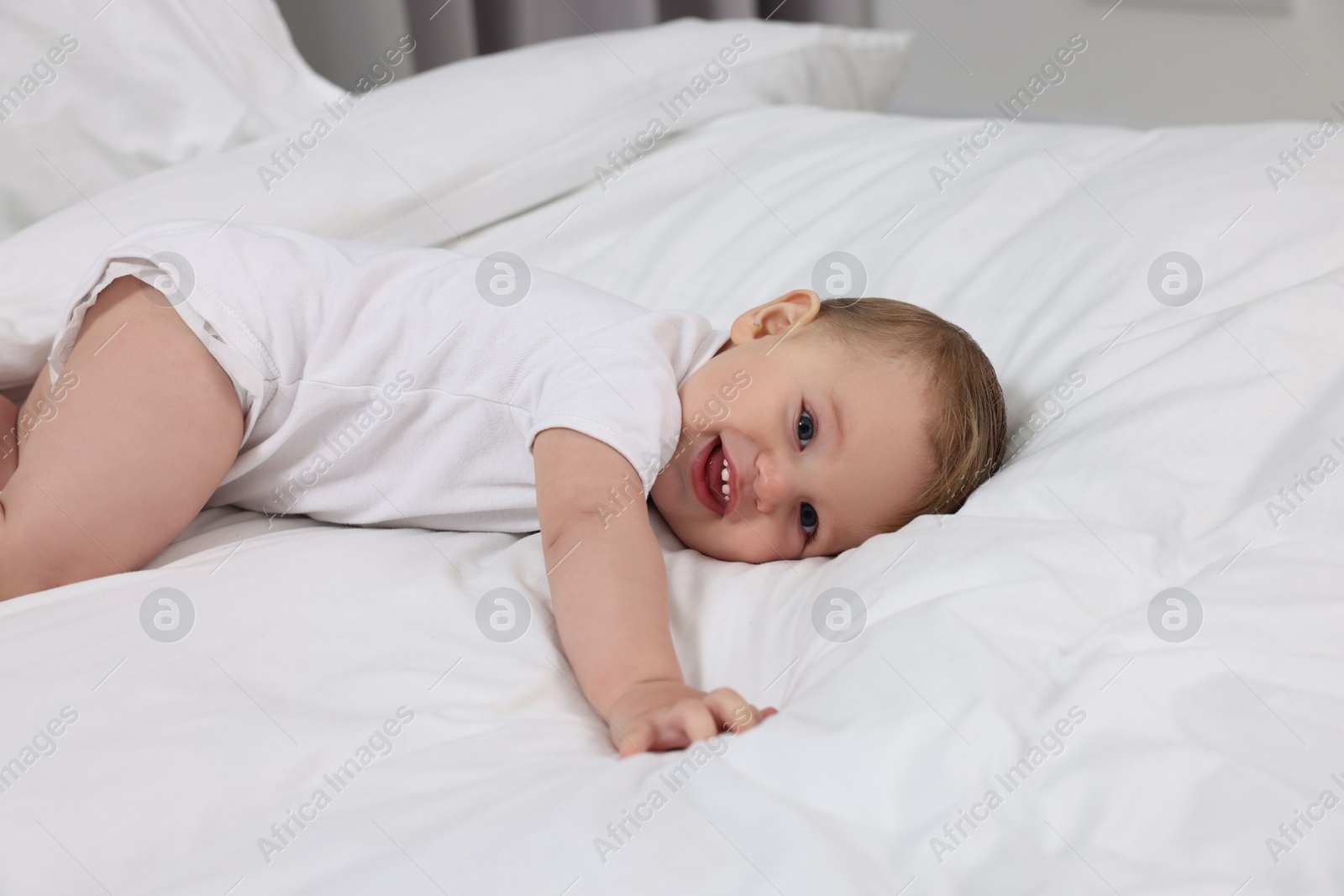 Photo of Funny little baby playing on bed at home