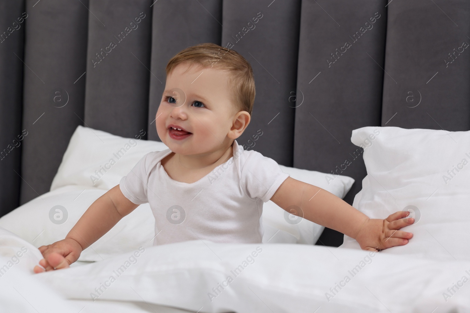 Photo of Funny little baby playing on bed at home