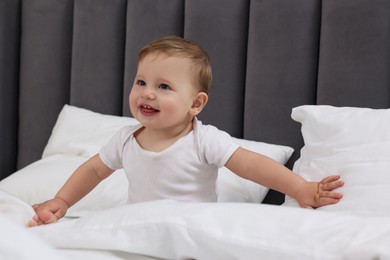 Photo of Funny little baby playing on bed at home