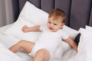 Photo of Funny little baby playing on bed at home