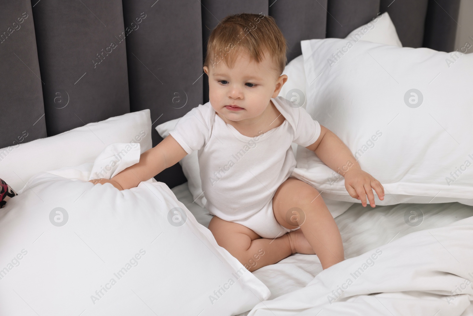 Photo of Funny little baby playing on bed at home