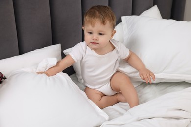 Photo of Funny little baby playing on bed at home