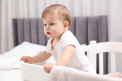 Photo of Cute little baby in crib at home