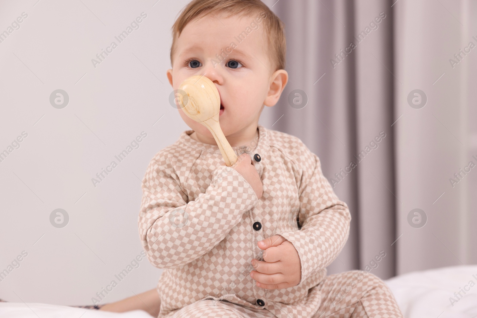 Photo of Adorable little baby with toy on bed at home