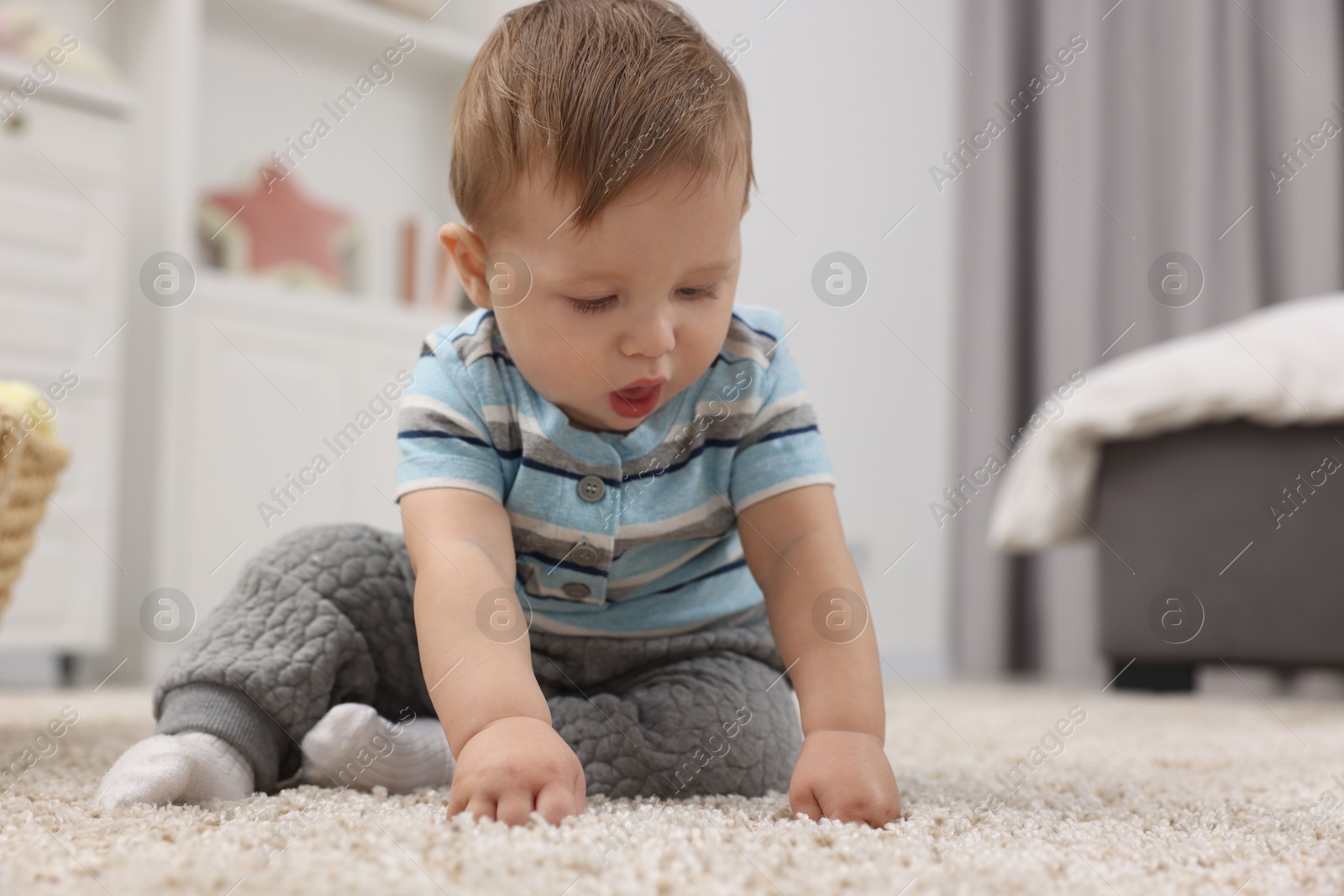 Photo of Adorable baby boy on floor at home