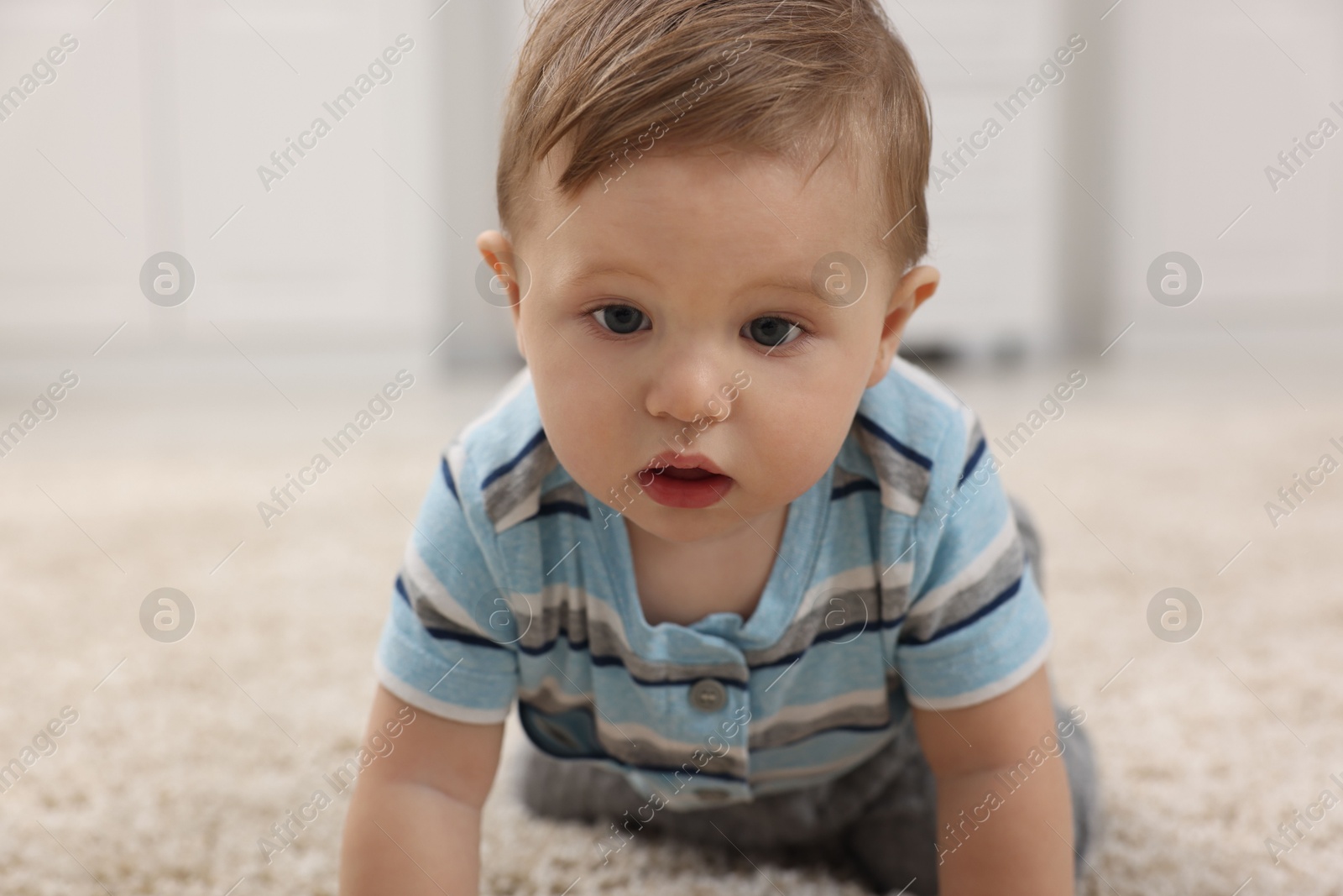 Photo of Adorable baby boy on floor at home