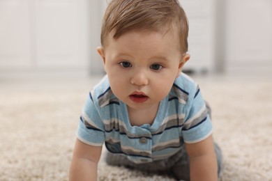 Photo of Adorable baby boy on floor at home