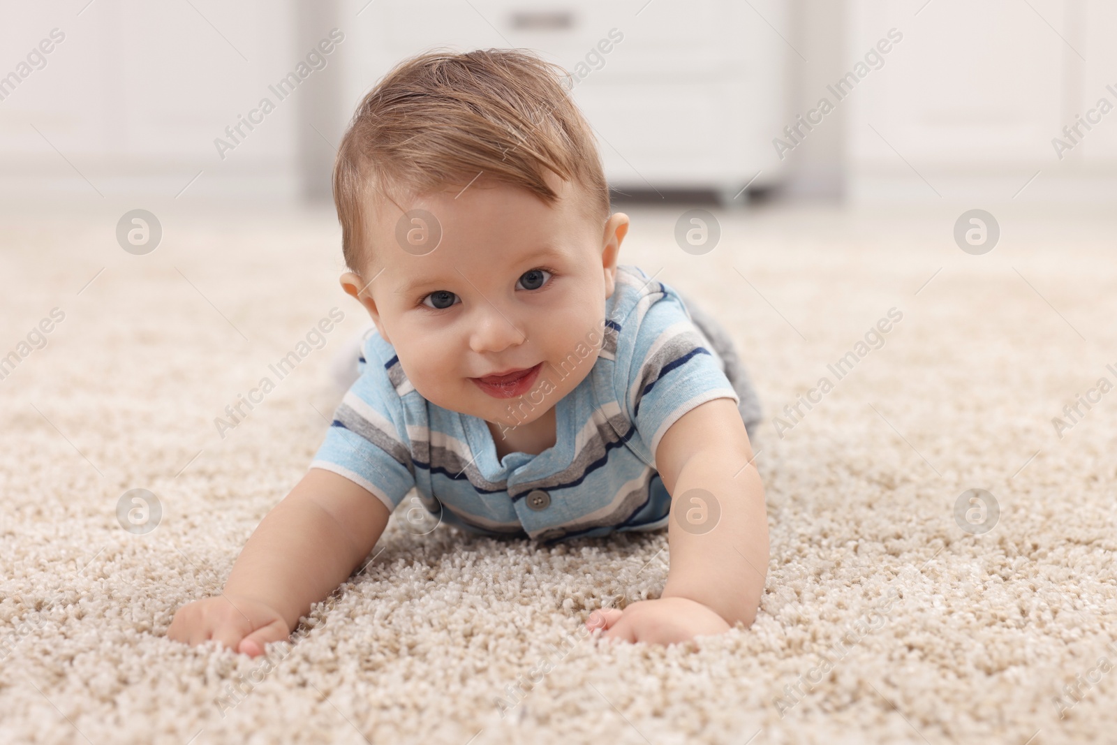 Photo of Adorable baby boy on floor at home