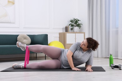 Photo of Woman training with resistance band at home