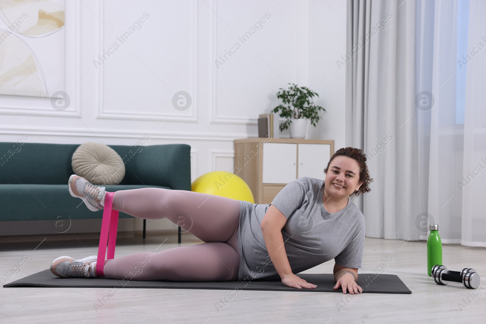 Photo of Woman training with resistance band at home