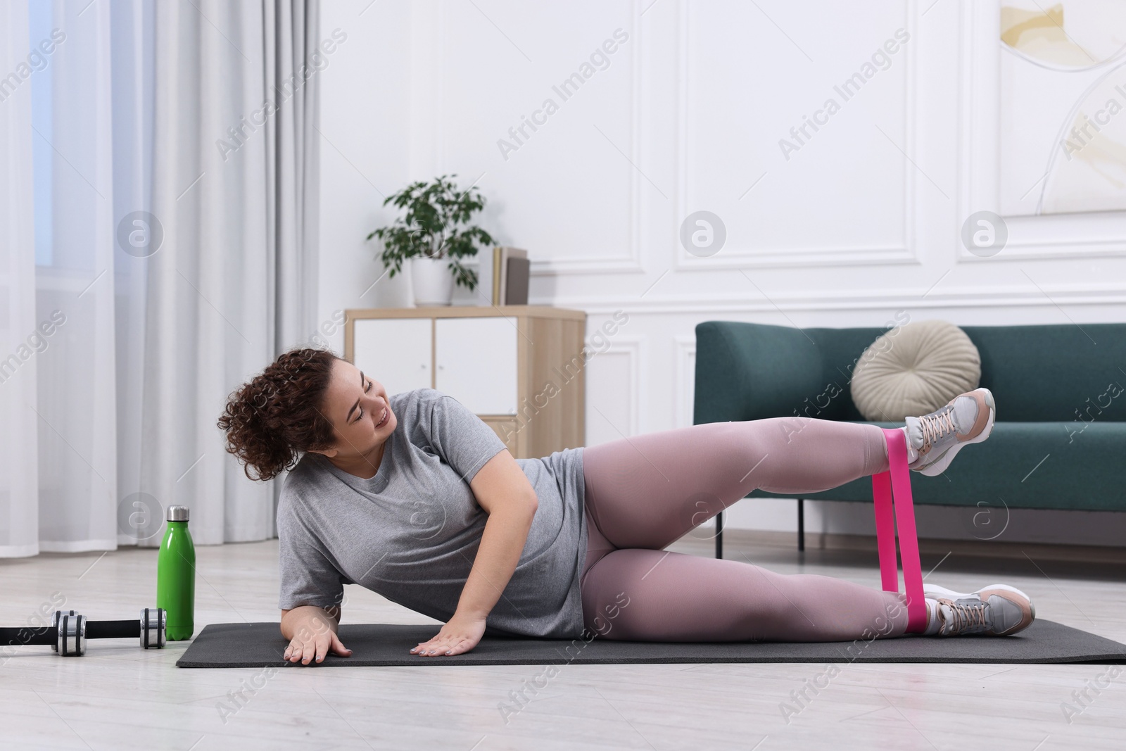 Photo of Woman training with resistance band at home